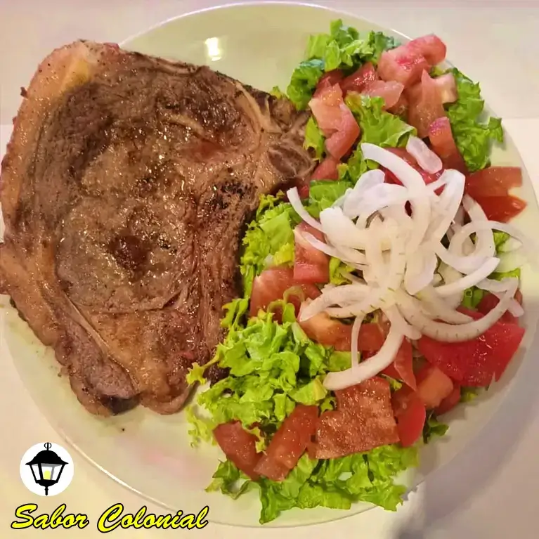 bife ancho con ensalada de lechuga, tomate y cebolla