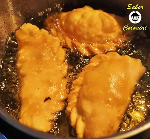 Empanadas fritas cocinándose en aceite caliente – Sabor Colonial